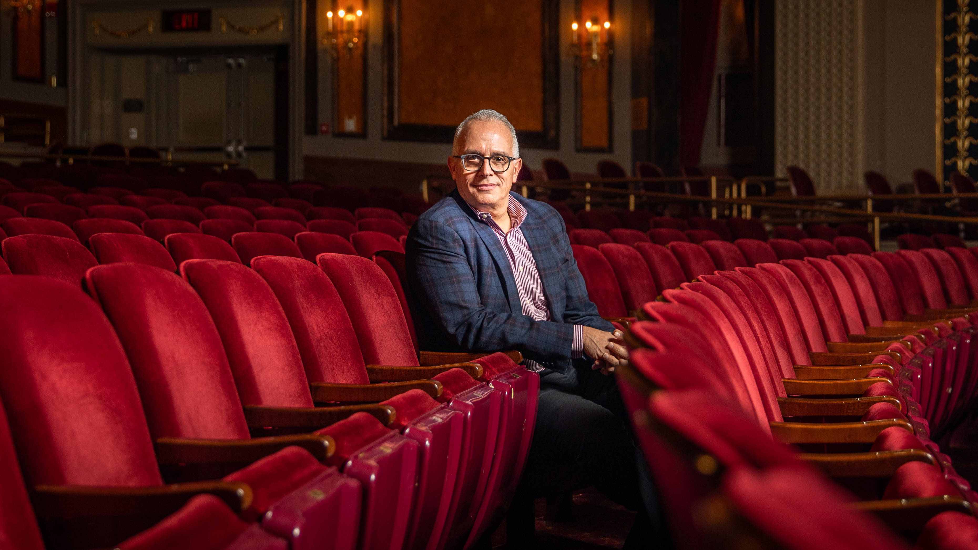 Frank Tavera sitting in the red seats at The Palace Theater is Waterbury CT