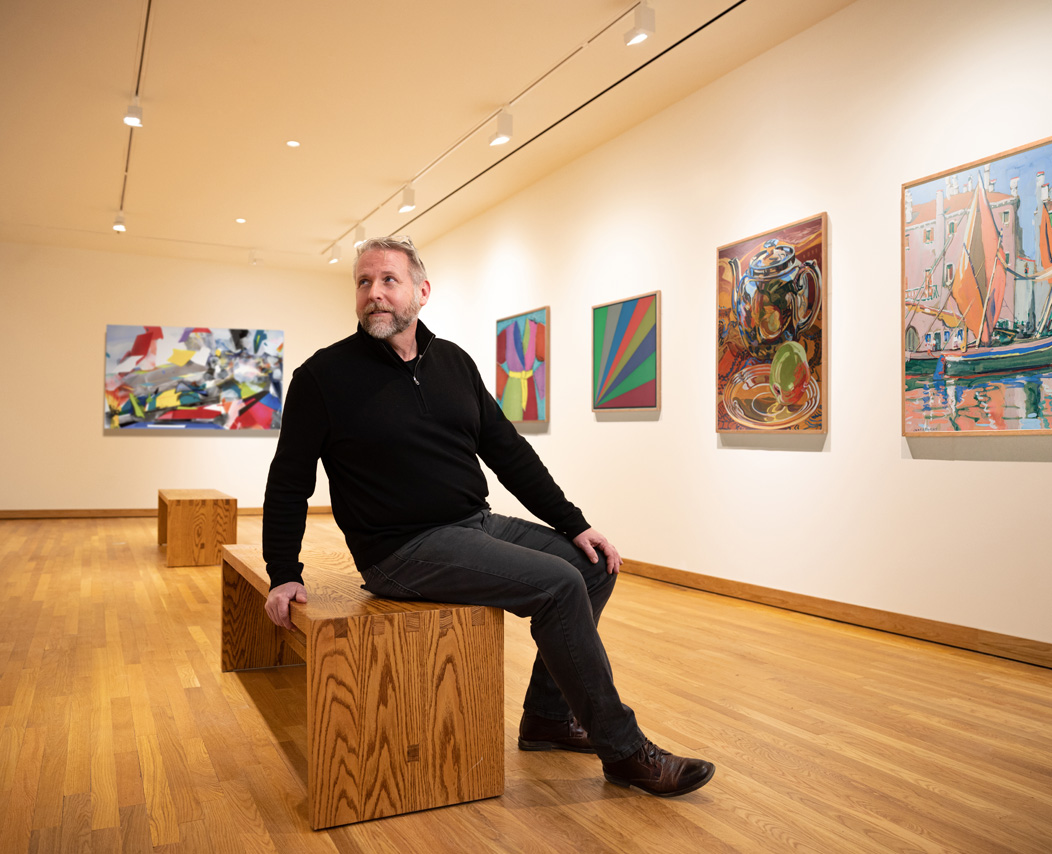 Bob Burns sitting on a viewing bench in one of the art galleries at the Mattatuck Museum