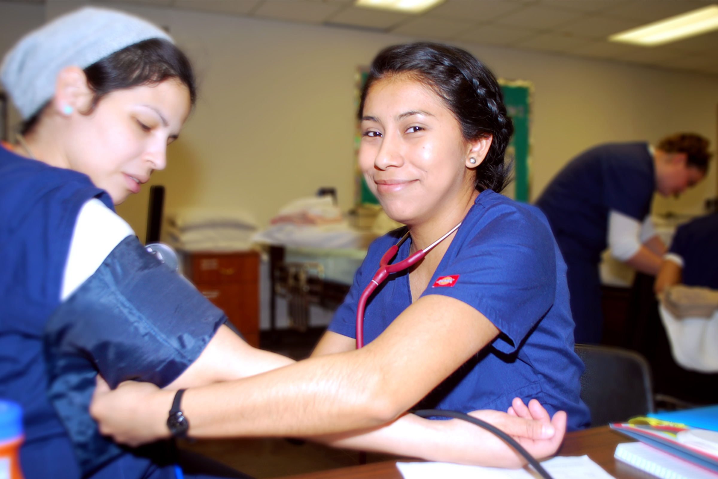 Medical student from Naugatuck Valley Community College testing a womans blood pressure