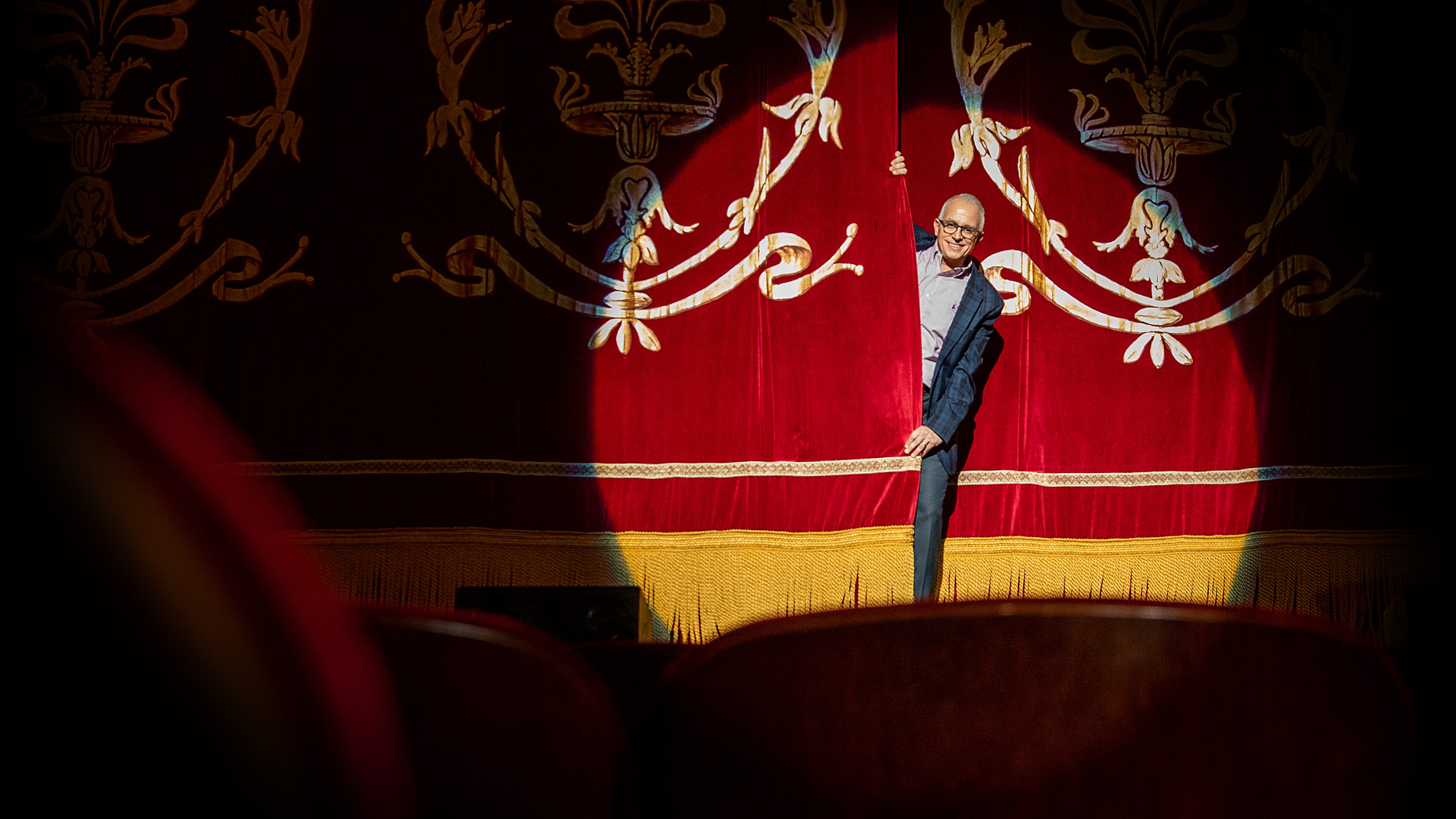 Frank Tavera peeking through the curtains on The Palace Theater stage in Waterbury CT