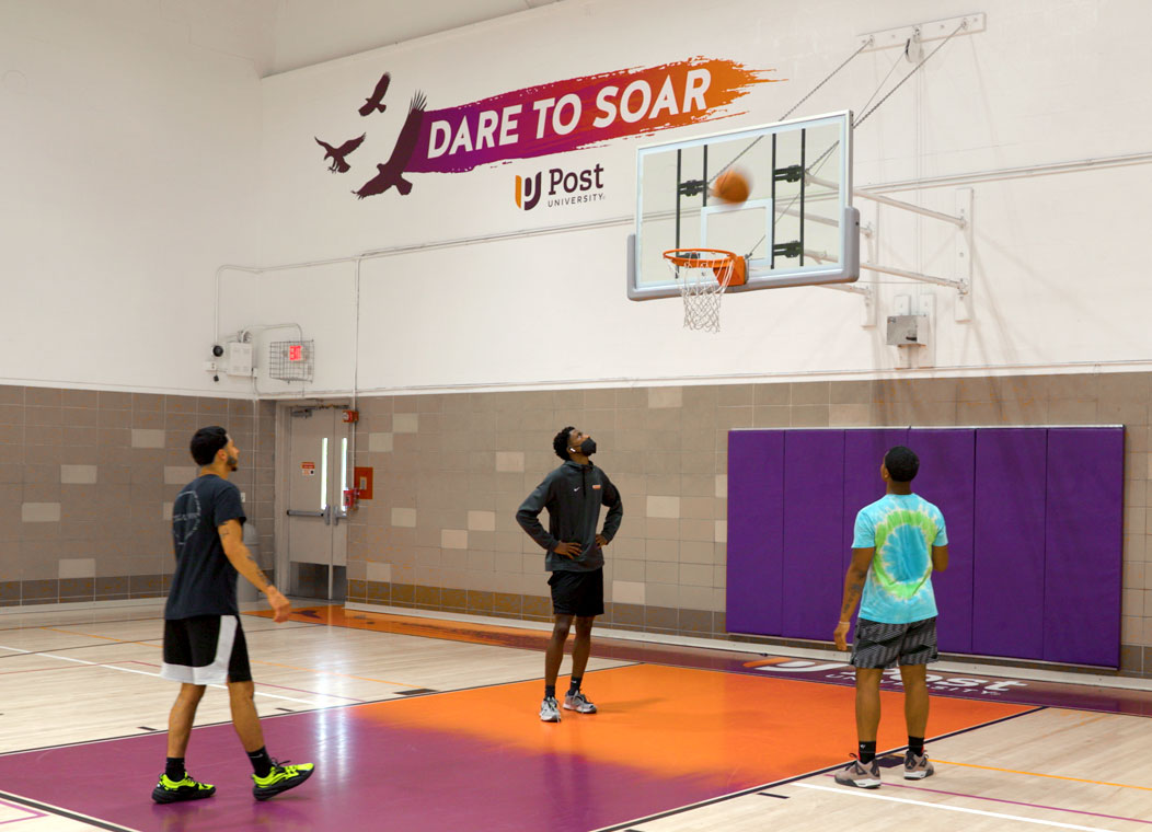 YMCA members shoot hoops on the refurbished, Post University-branded basketball courts.