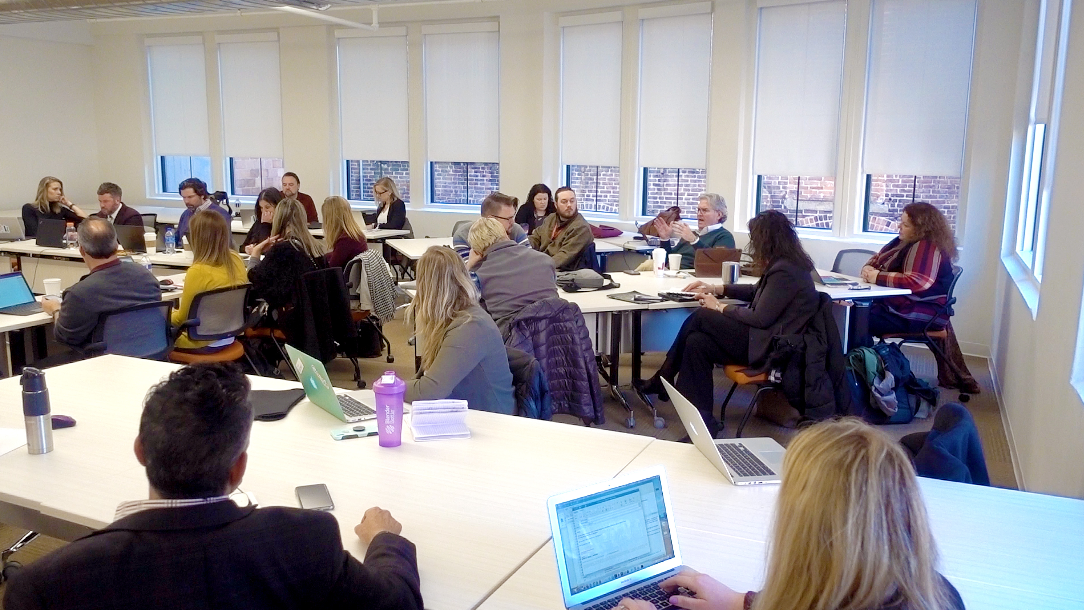 John Hopkins sits in a full classroom among Post University students in Waterbury CT