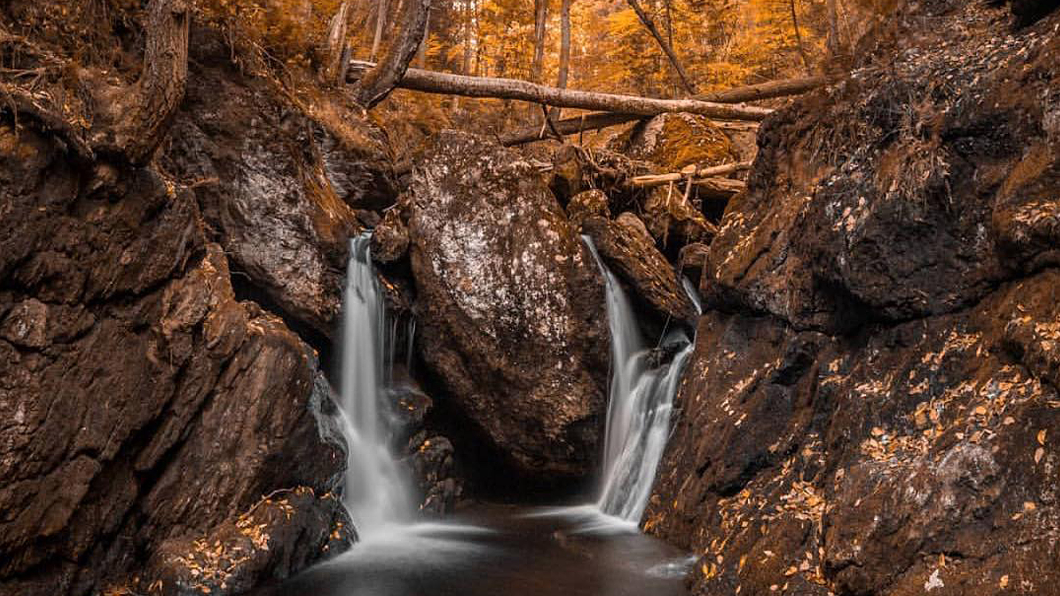 Two small waterfalls flowing through the rocks in the woods of Beacon Falls CT