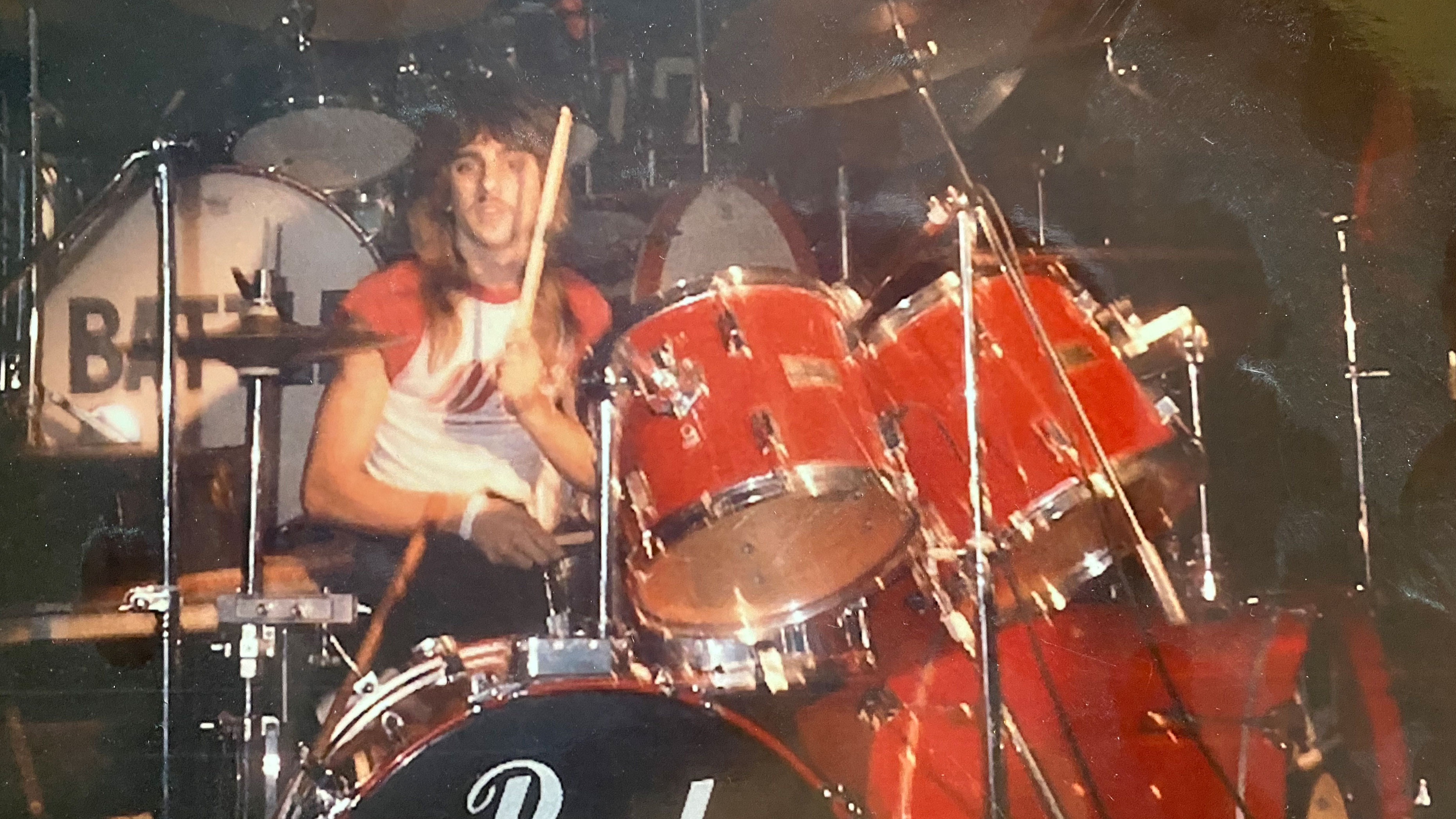 Photo of young Joe Gramando playing a red drumset