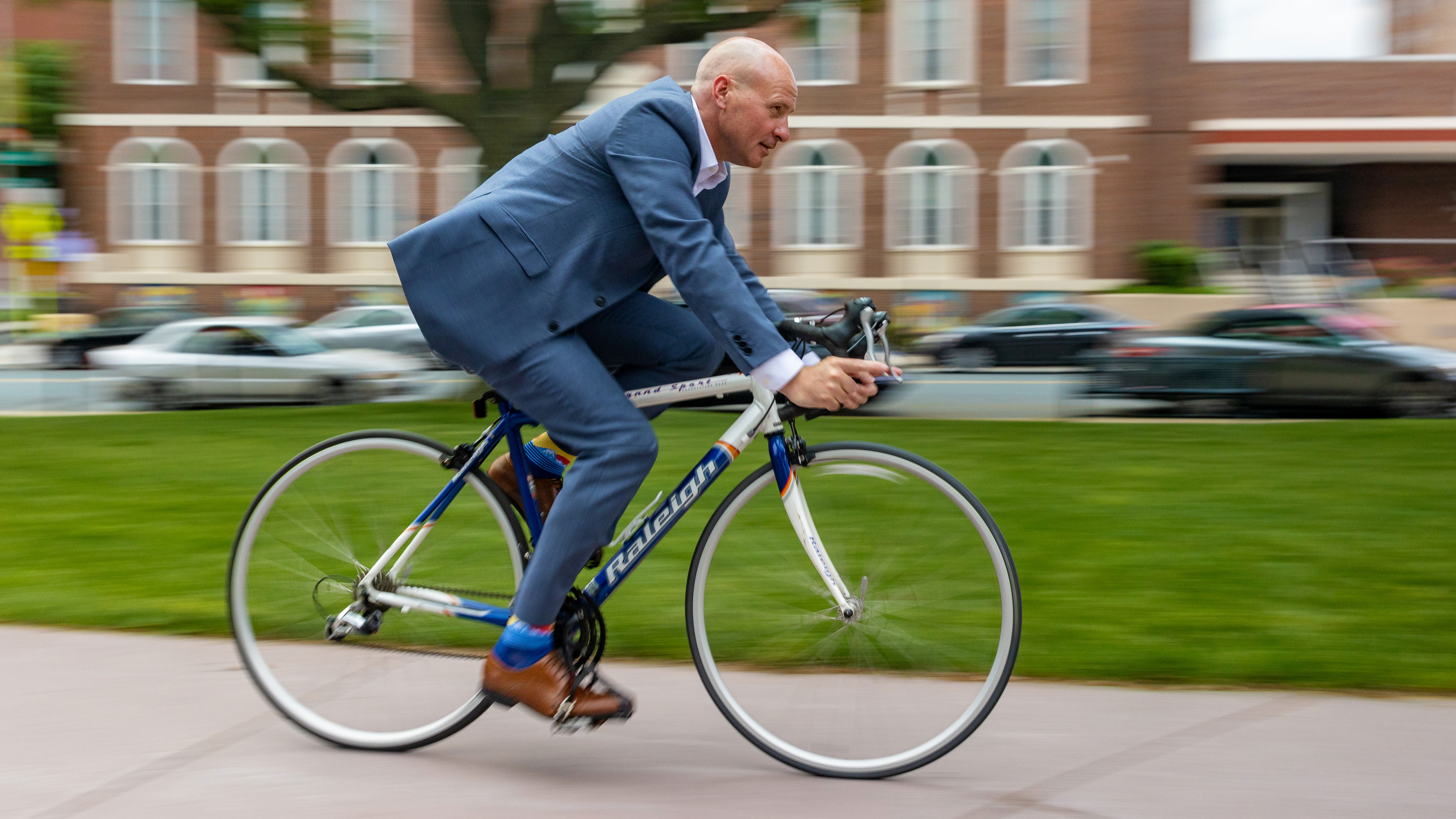 Ironman triathlete Jim O'Rourke cycling on the Waterbury Green