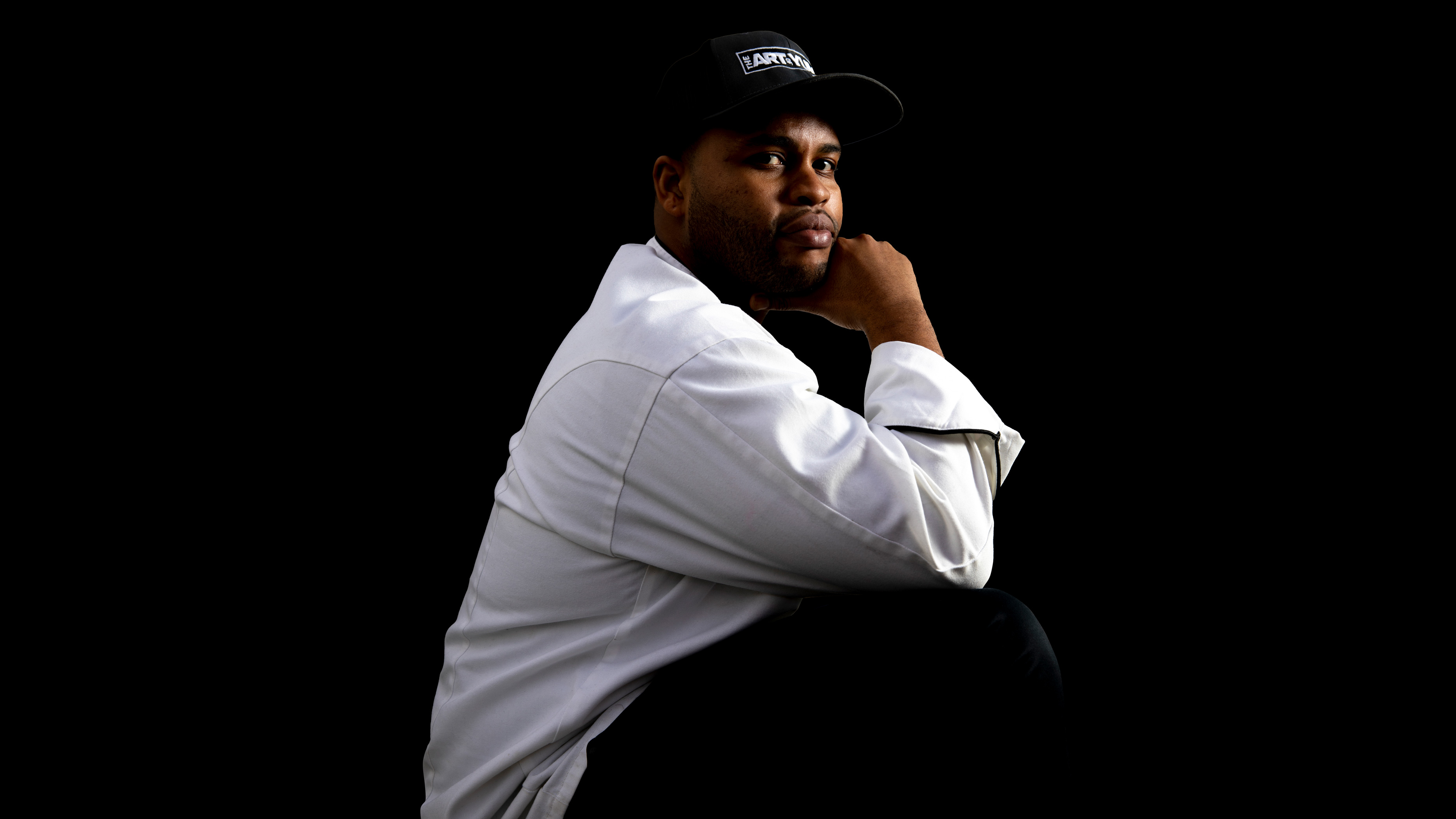 Portrait of The Art Of Yum chef Donte Jones on a black background
