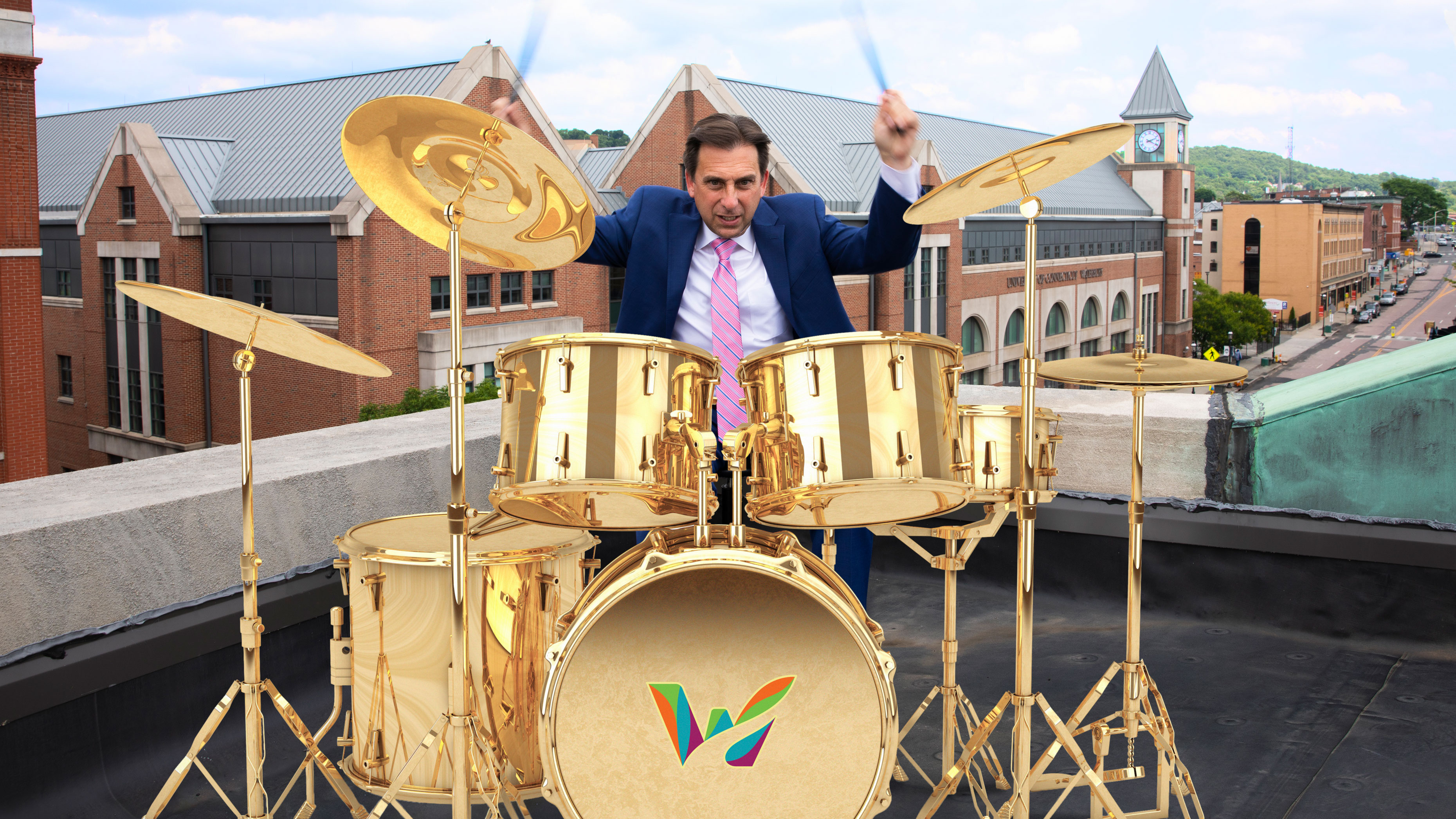 Joe Gramando playing drums on a rooftop in Waterbury CT, drumset showing the Waterbury logo