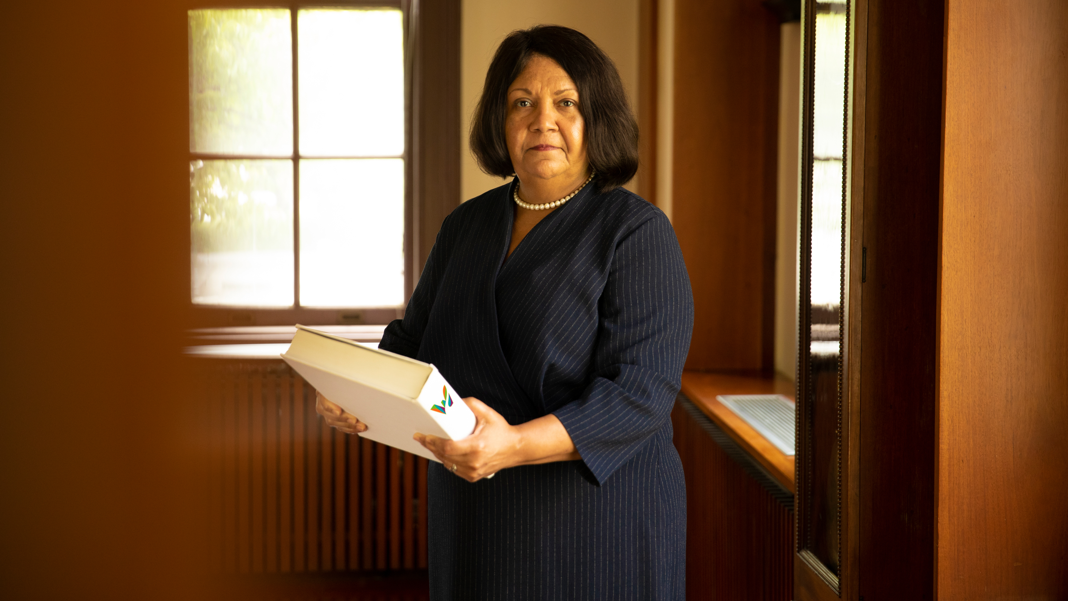 Superintendent of Waterbury Public Schools Verna Ruffin holding a large book with the Waterbury logo