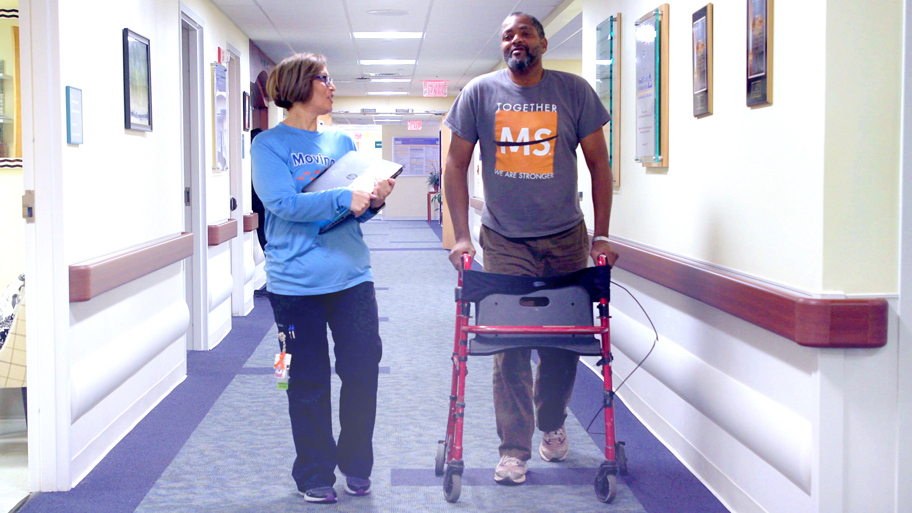 Medical team member and patient walking the hallway at the Multiple Sclerosis Center