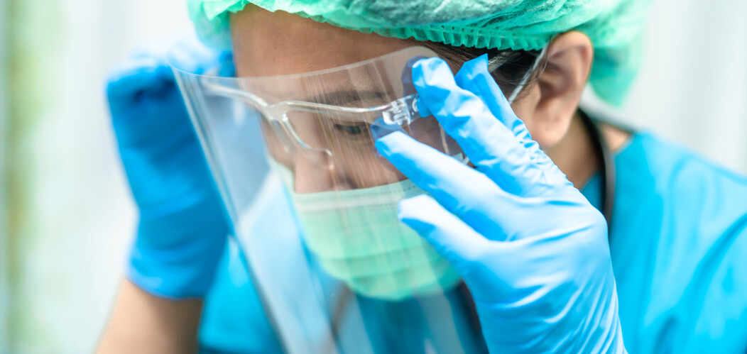 Female healthcare worker wearing PPE mask and protective gloves