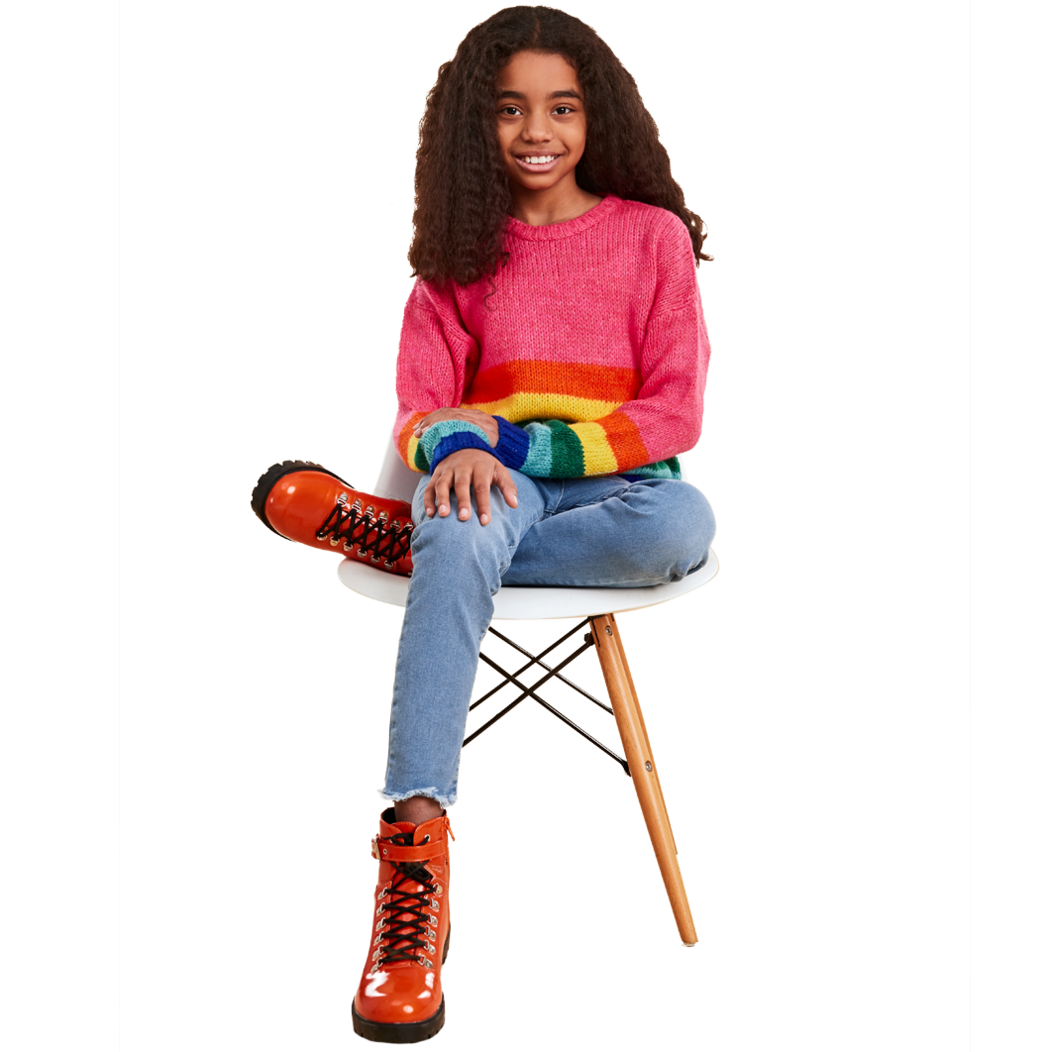 Young female sitting in chair wearing a colorful sweater