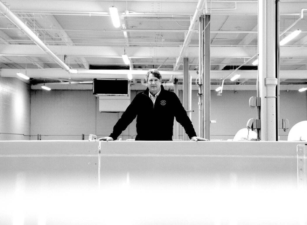 Eric Pedersen overlooking saltwater fish tanks inside the Ideal Fish facility