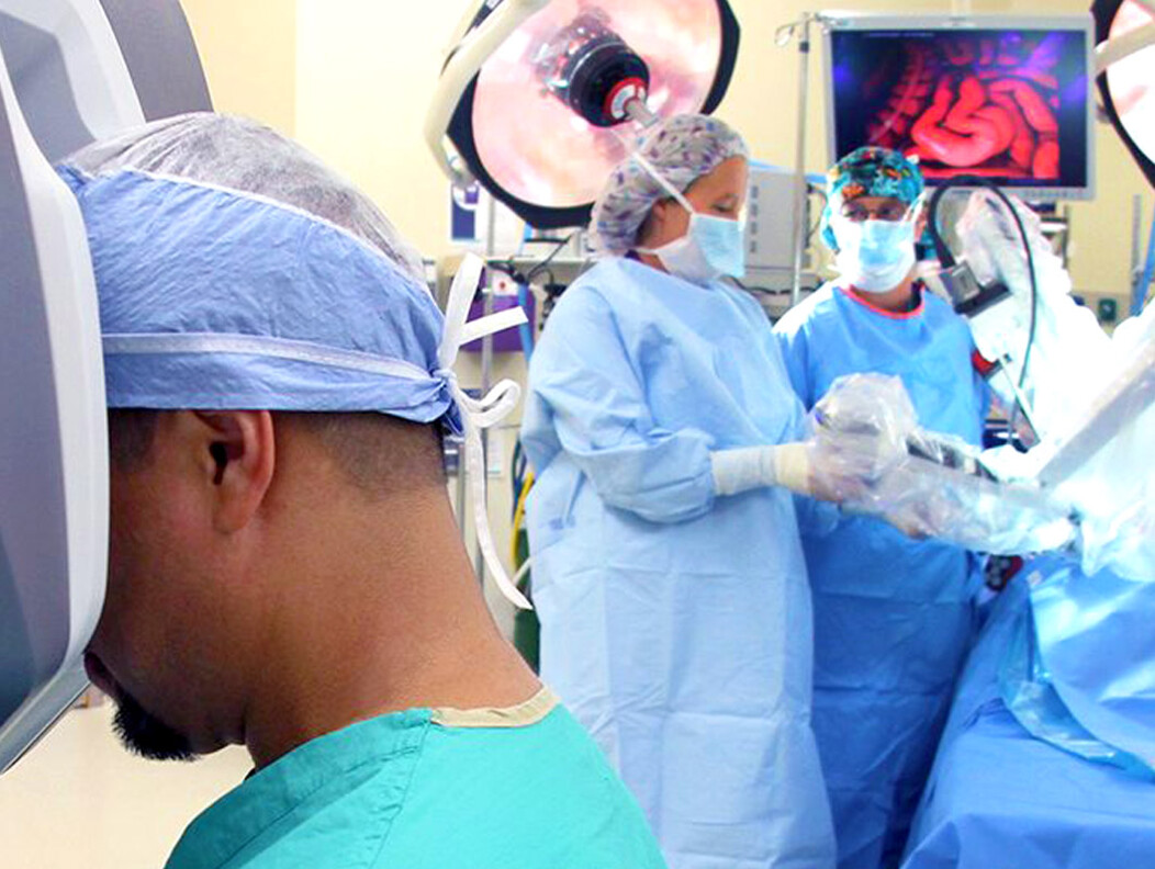 Three doctors at Waterbury Hospital in surgical gear performing robotic surgery