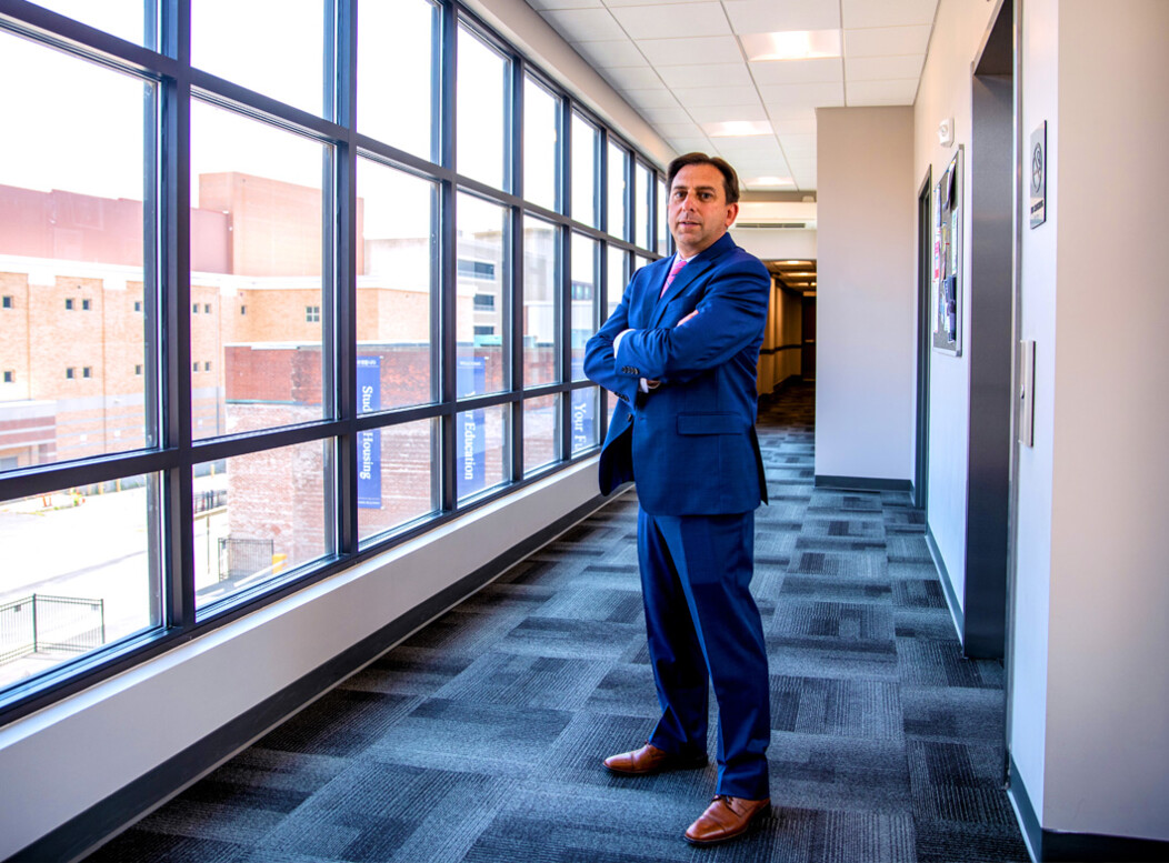 Joe Gramando standing in front of hallway windows with a view of Waterbury, arms crossed